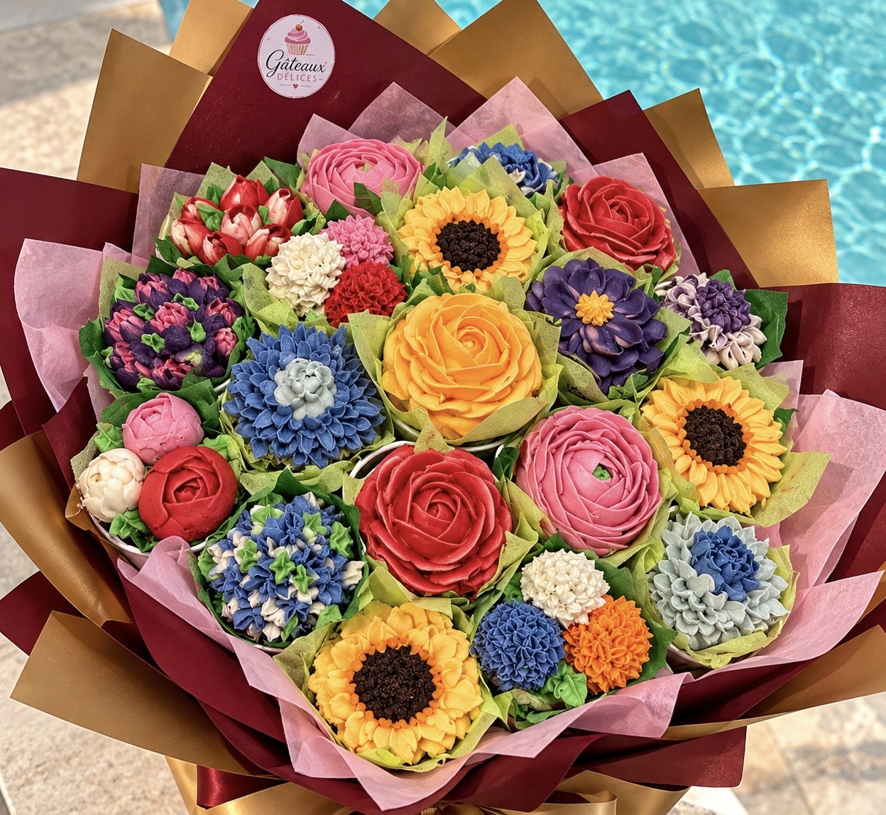 Bouquet de cupcakes fleuris multicolores, photographié près de la piscine